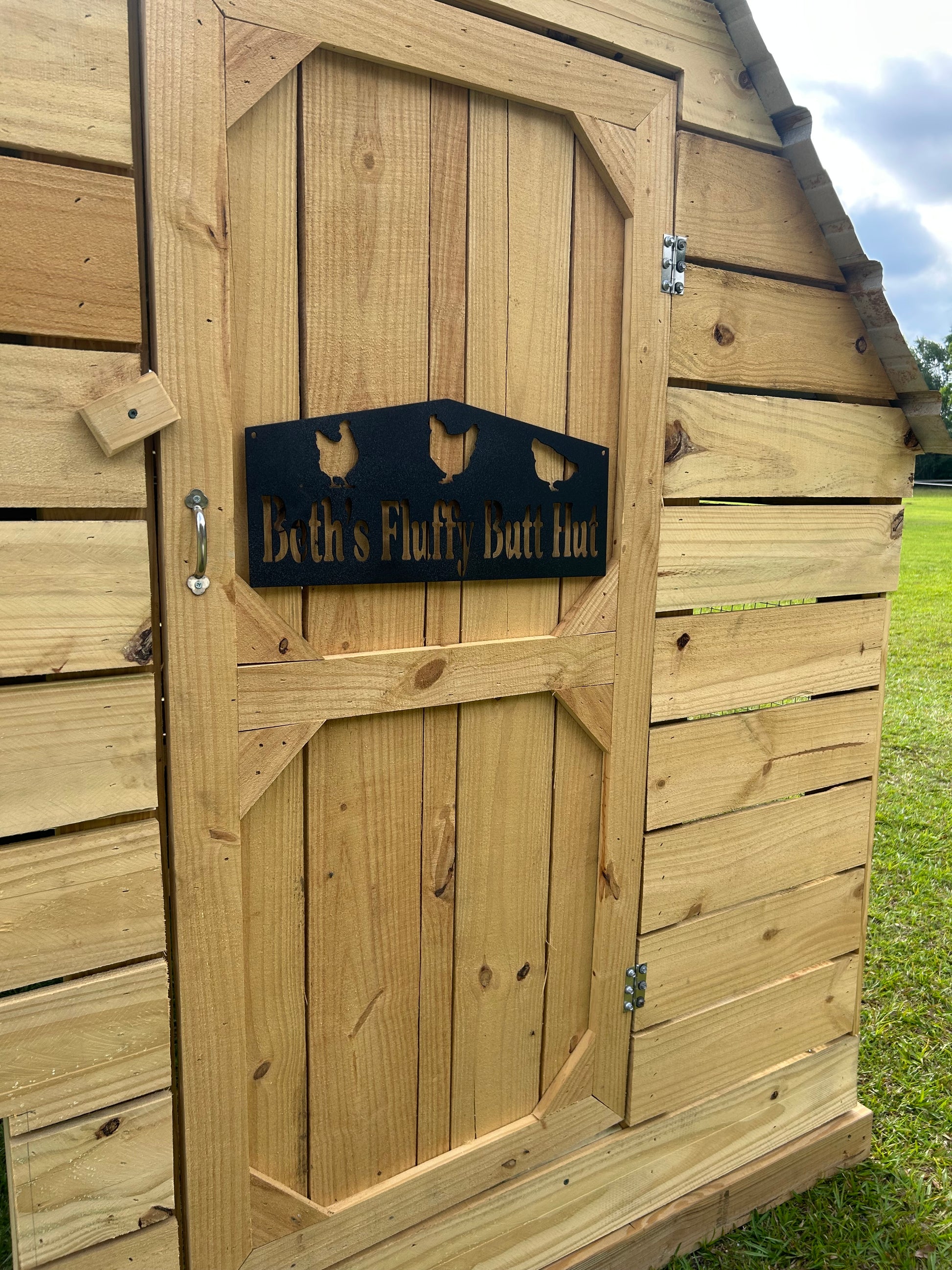 Wooden chicken coop door with a sign