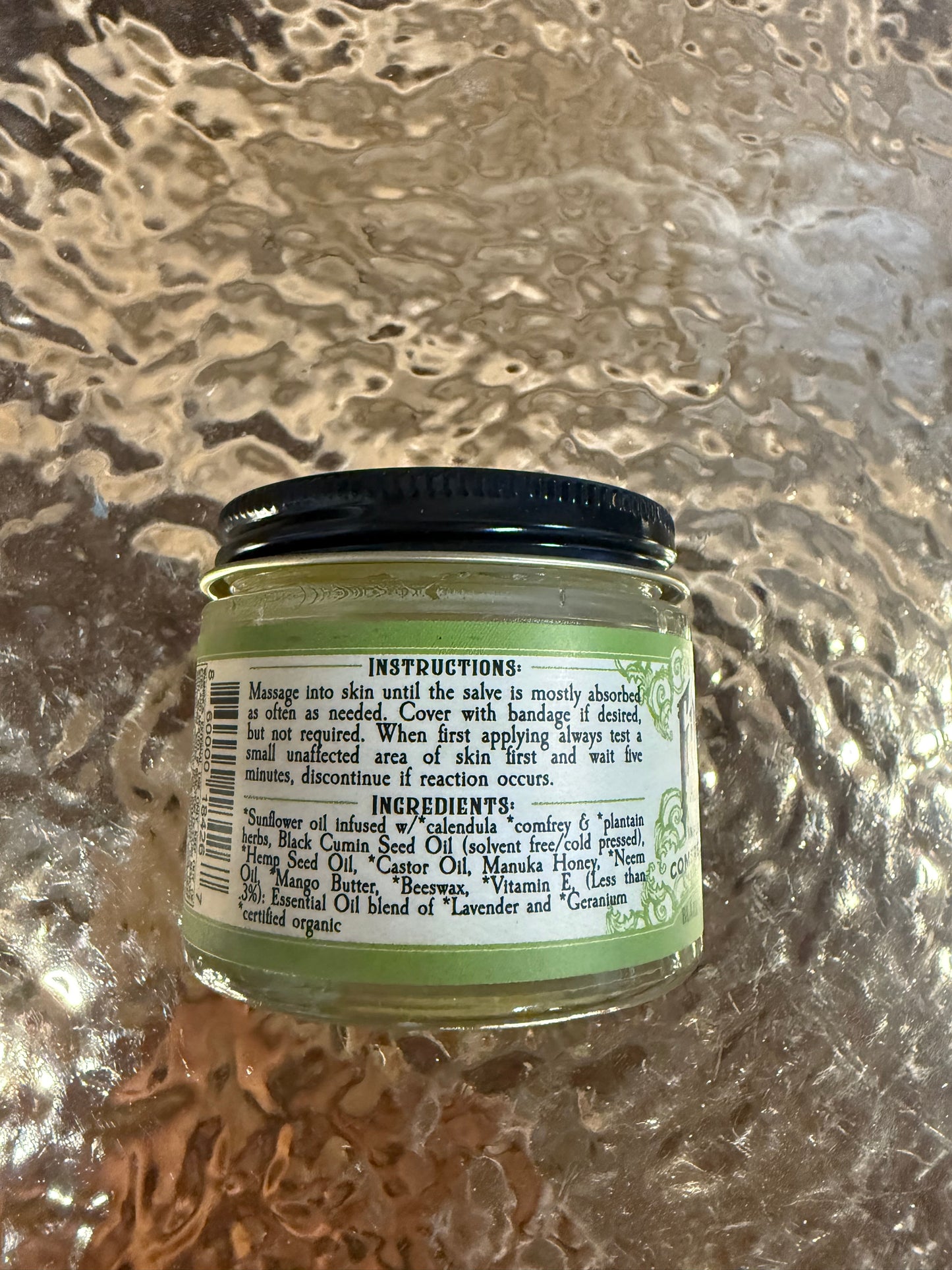 Small jar with a green label on a textured surface