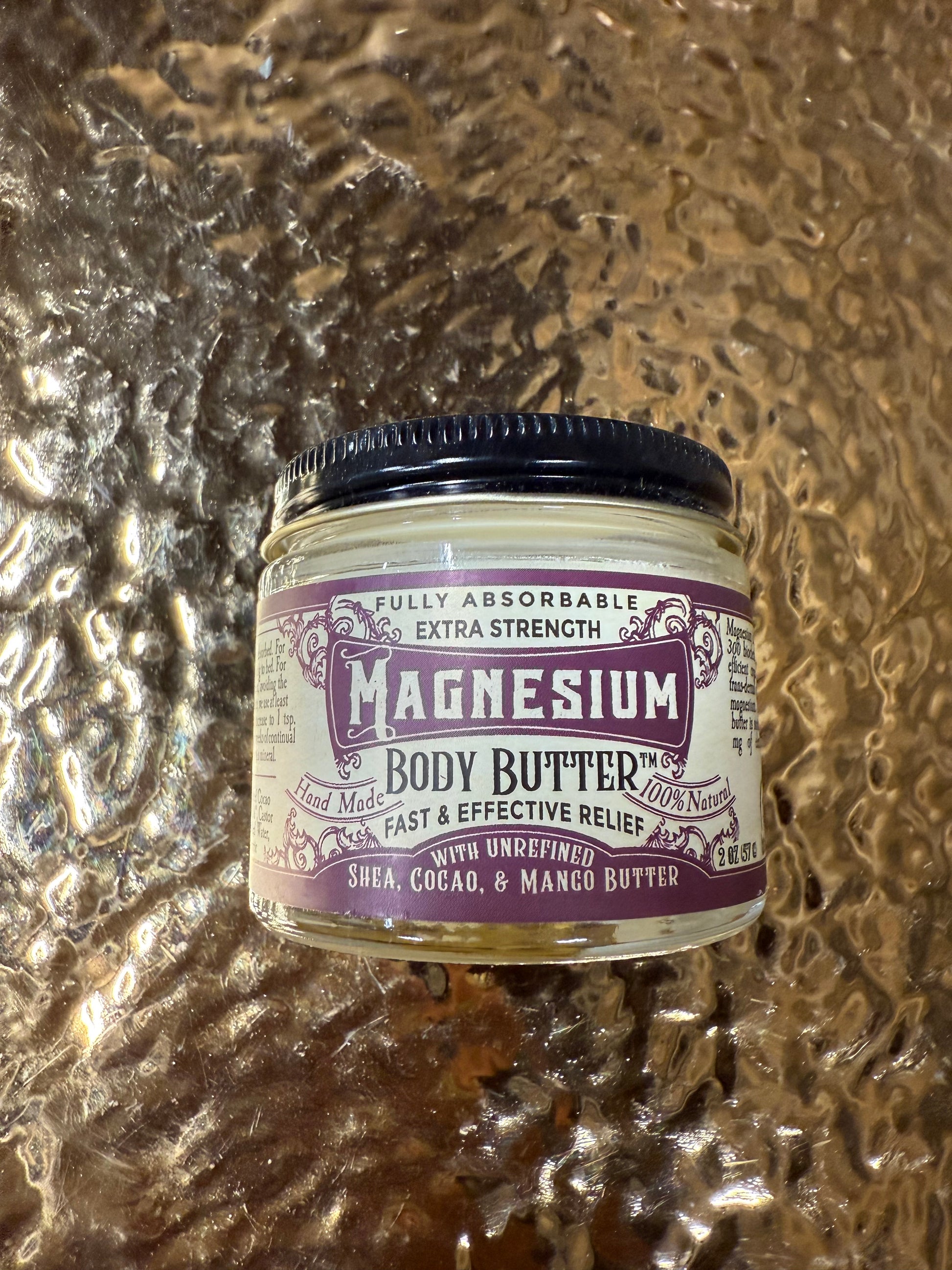 Jar of magnesium body butter on a textured surface