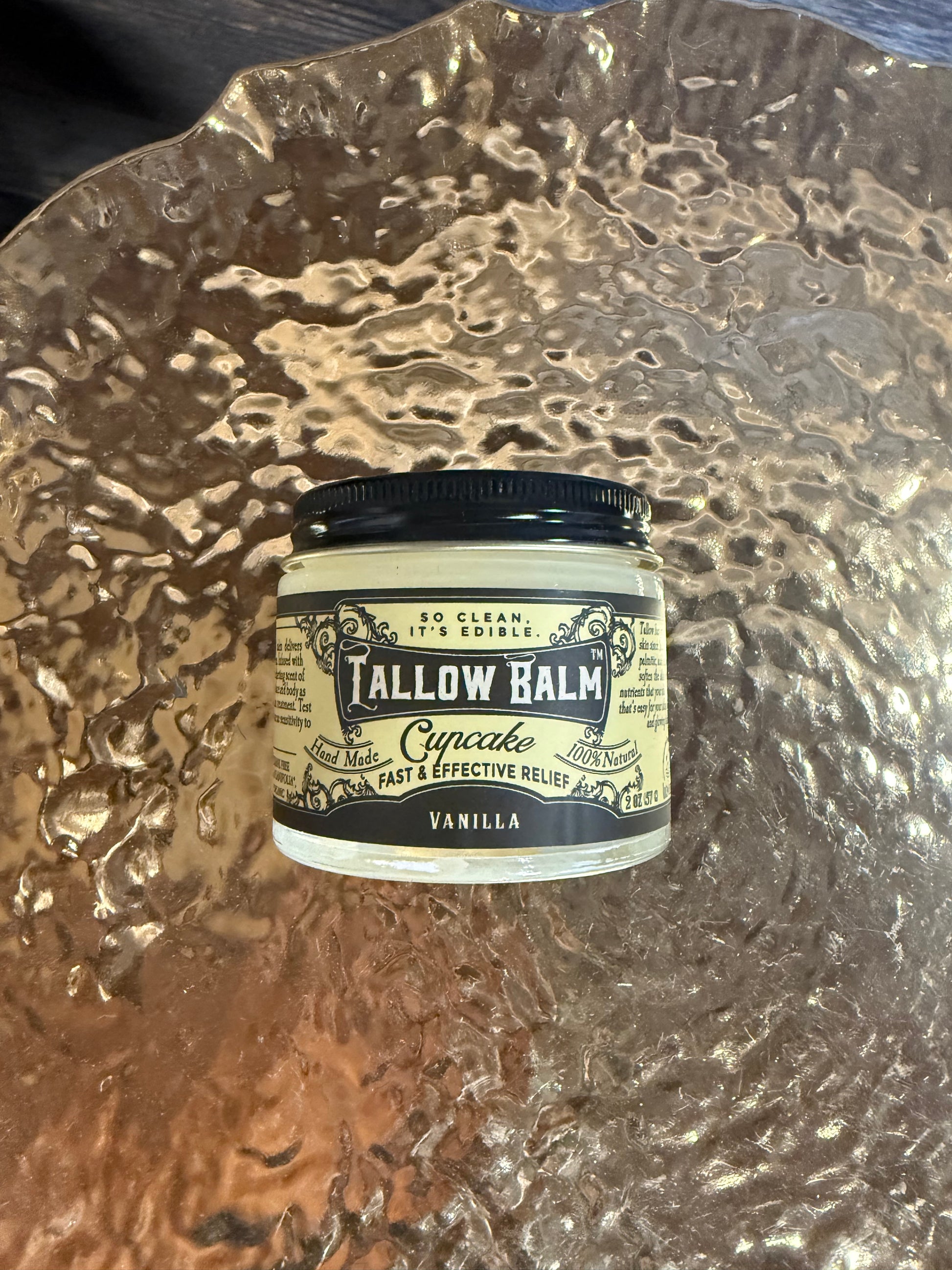 Tallow Balm container on a textured surface