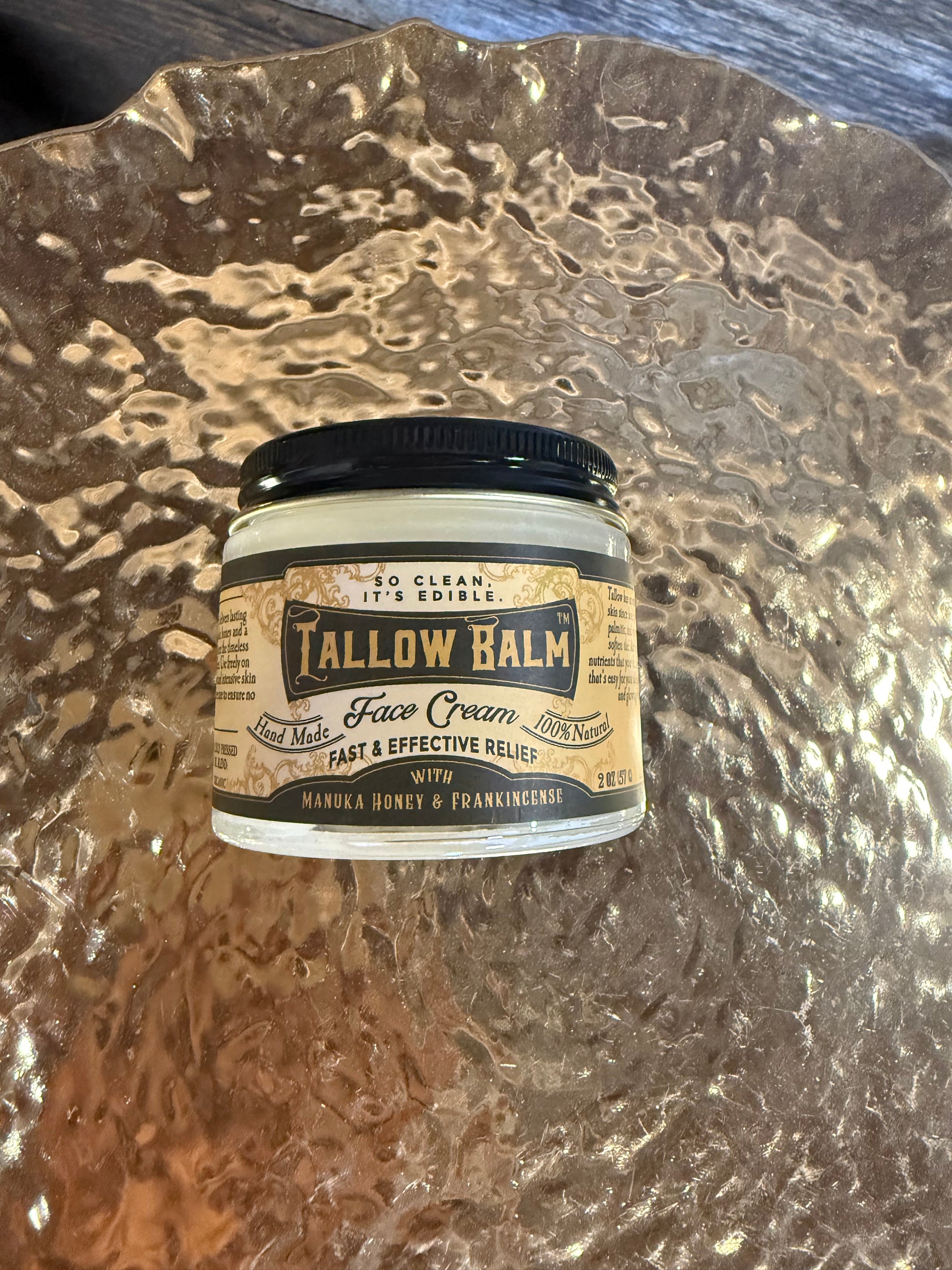 Tallow Balm container on a textured surface